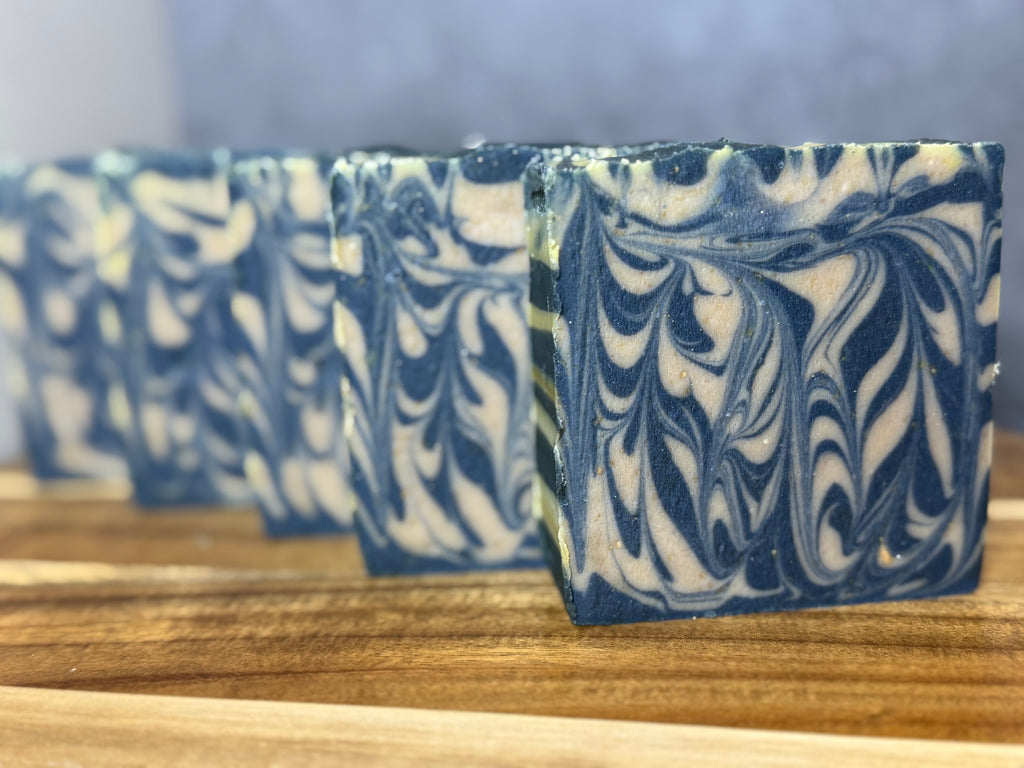 Marbled blue and white soap bars on a wooden surface. Goats Milk Honey Colloidal Oats