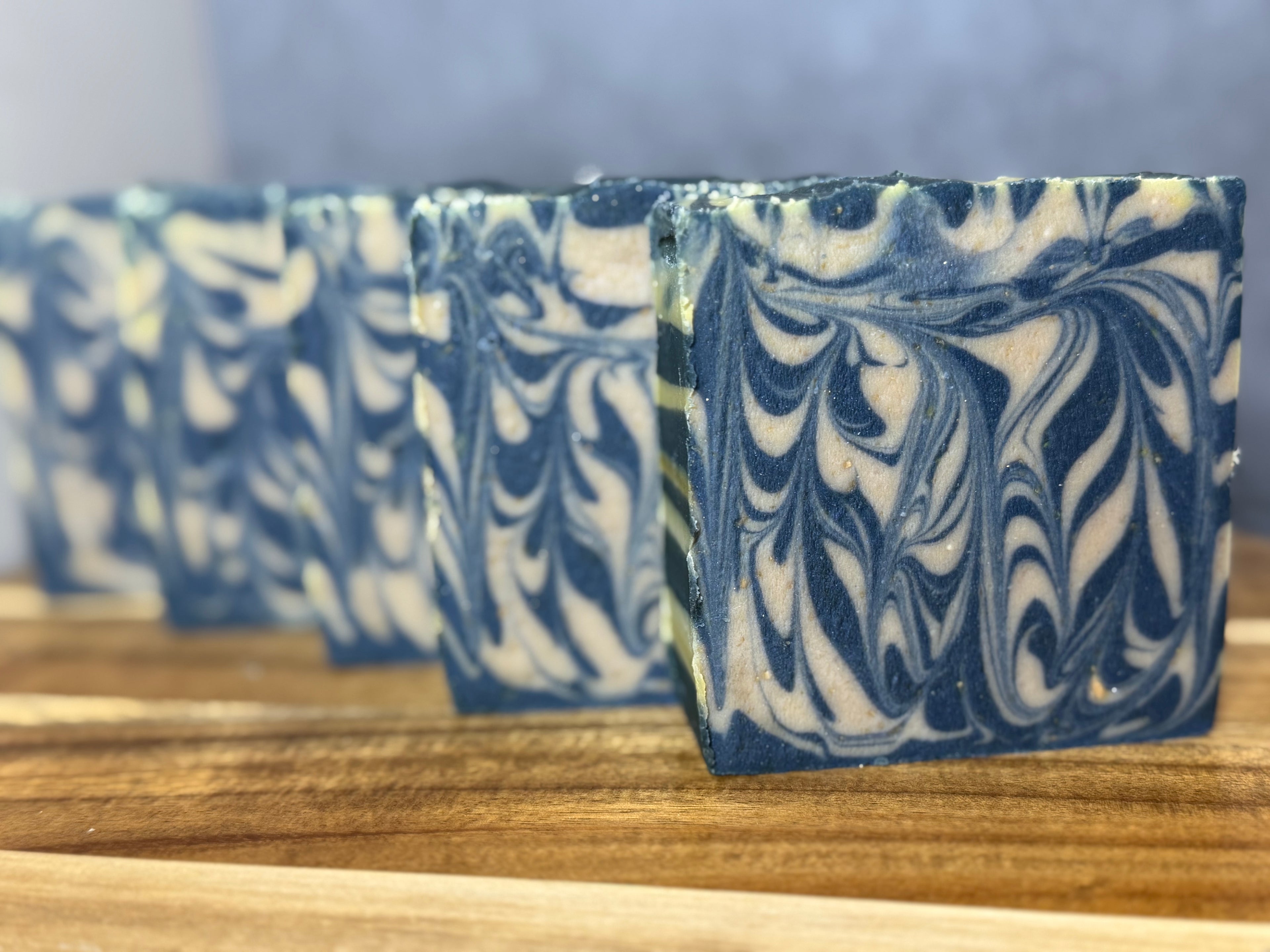 Marbled blue and white soap bars on a wooden surface. Goats Milk Honey Colloidal Oats