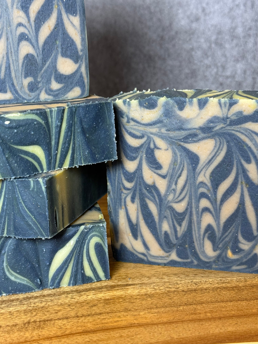 Marbled blue and white soap bars on a wooden surface. Goats Milk. Honey. Colloidal Oats