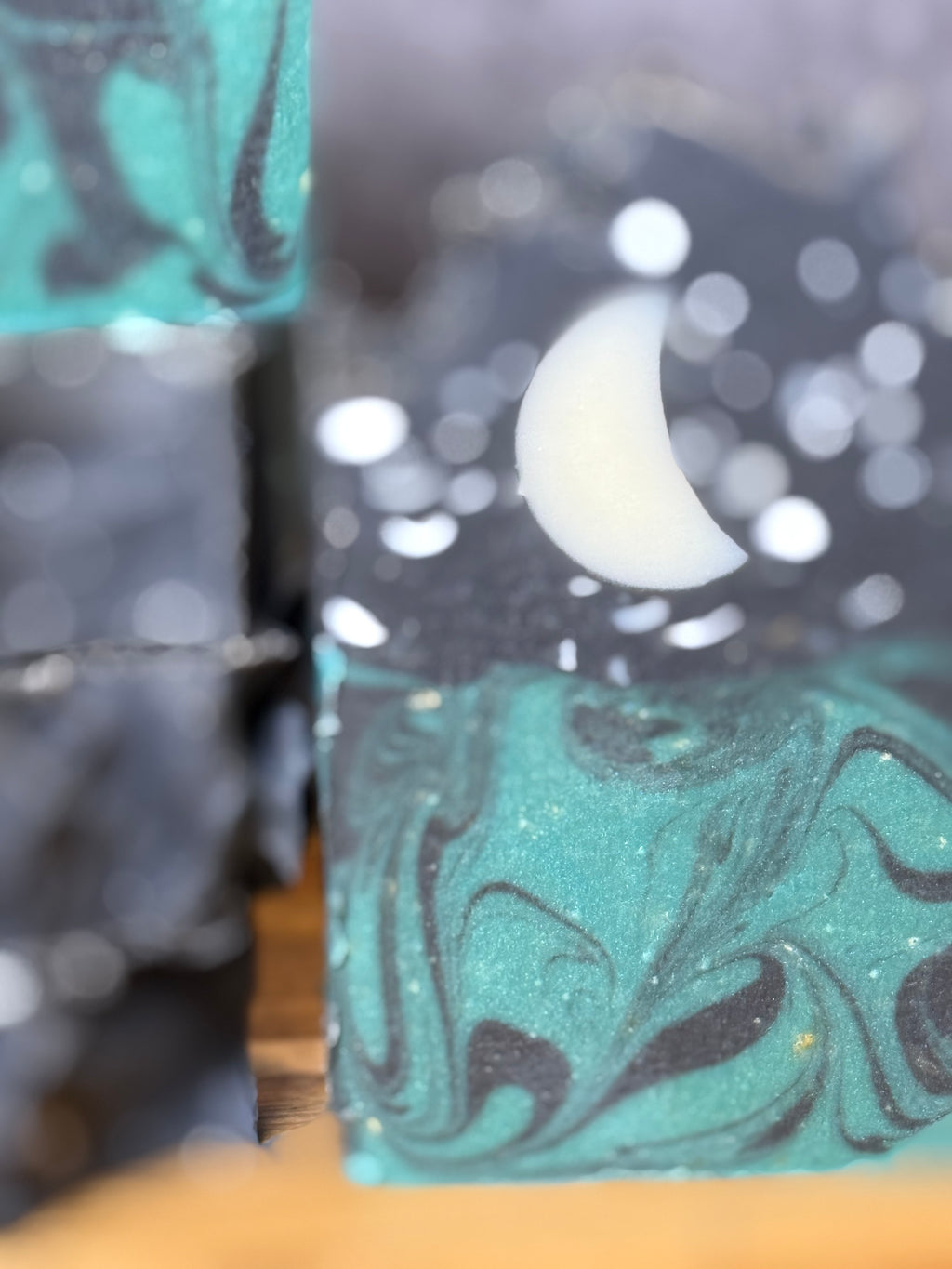 Marbled soap bars with black and green swirls on a wooden surface. Tallow and Goats Milk Soap with colloidal oats and honey.