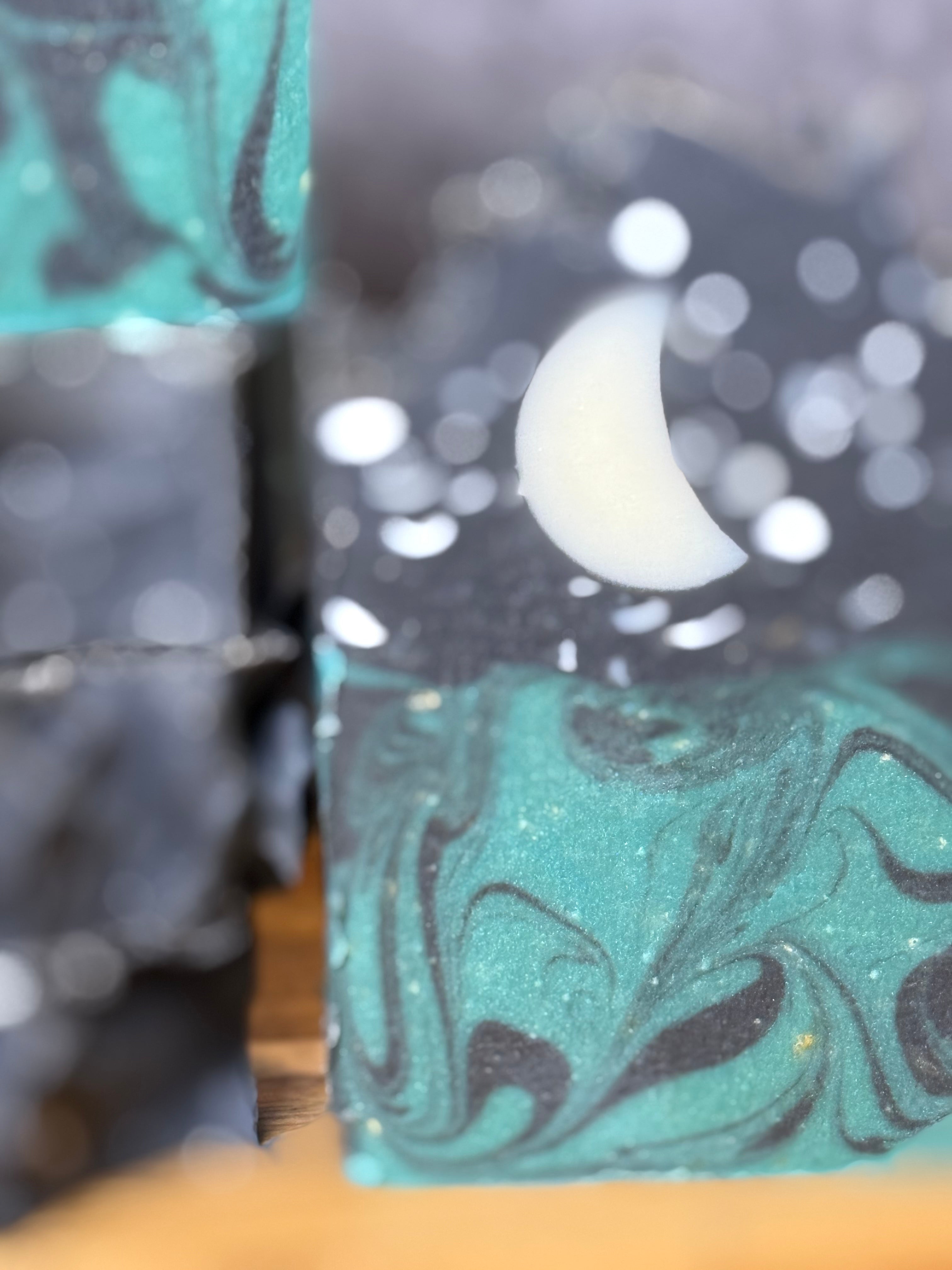 Marbled soap bars with black and green swirls on a wooden surface. Tallow and Goats Milk Soap with colloidal oats and honey.